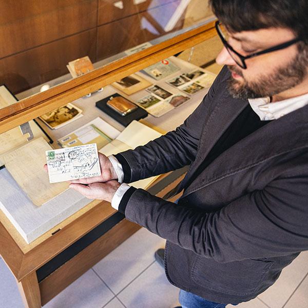 Michael Weisenburg holds up a postcard that is part of the Gatsby exhibit.